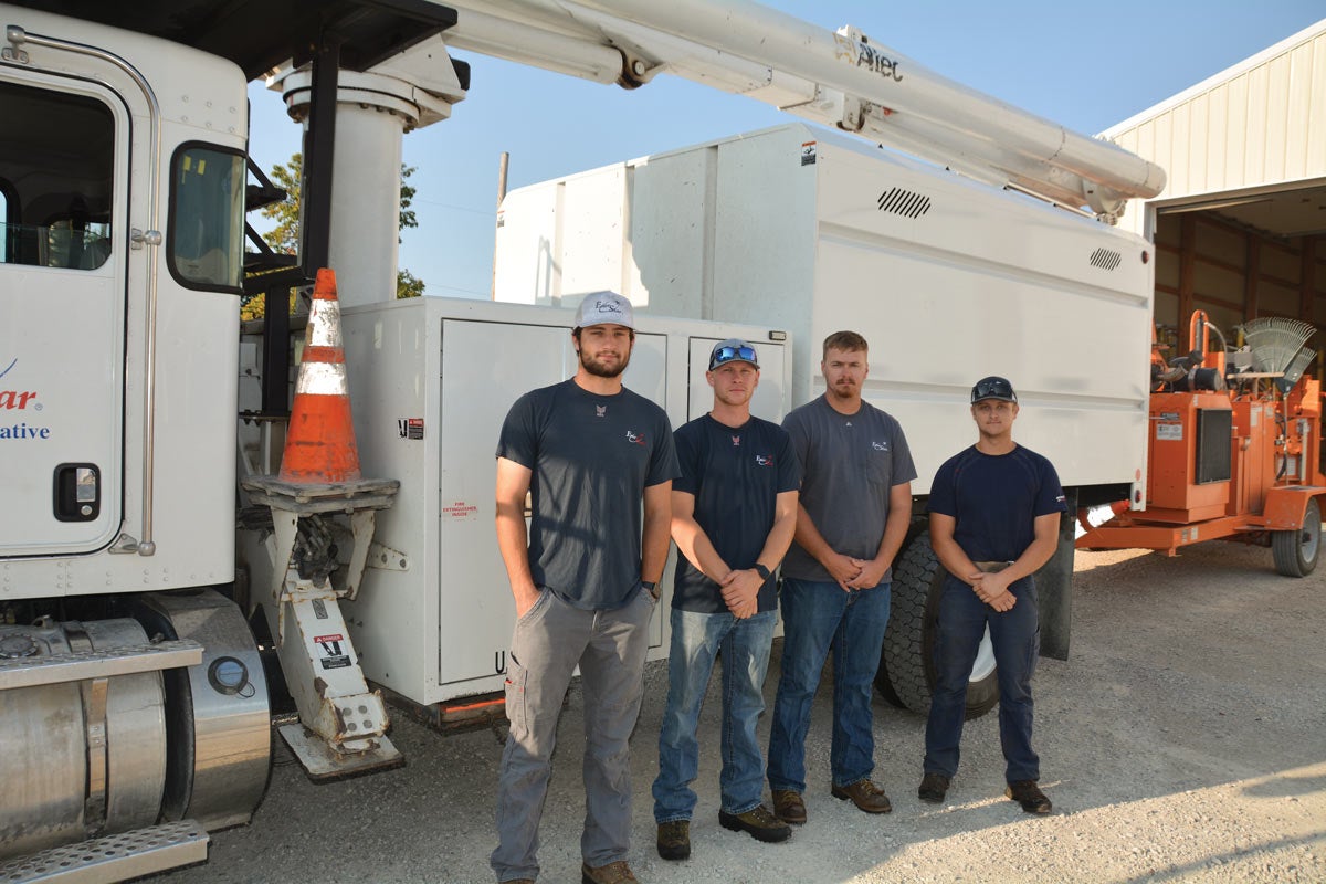 Four men standing in front of a bucket truck