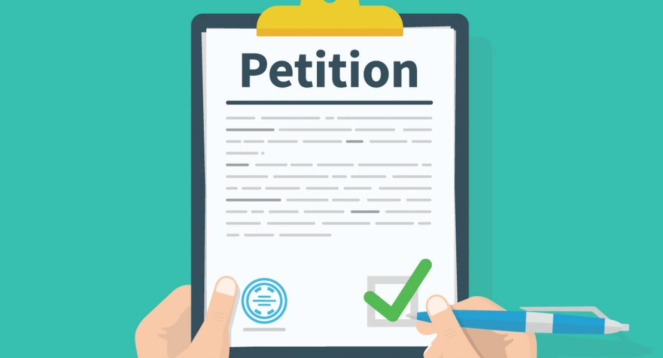 Hands holding a clipboard, checking a box on a page that reads Petition